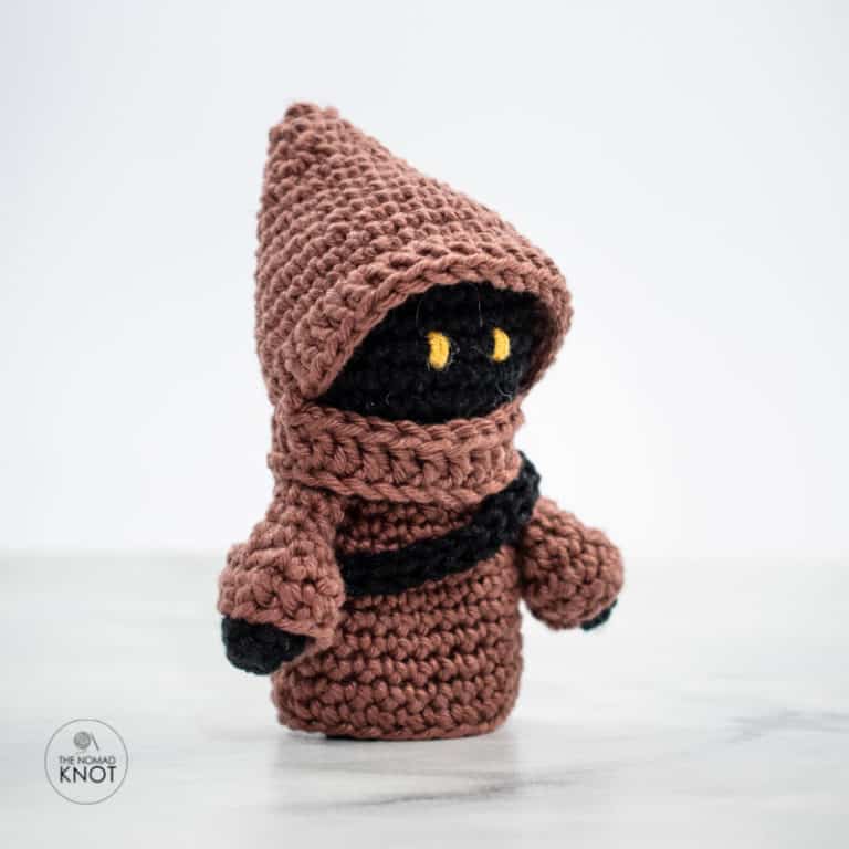 side shot of a Crochet Jawa free amigurumi pattern on top of a marble table