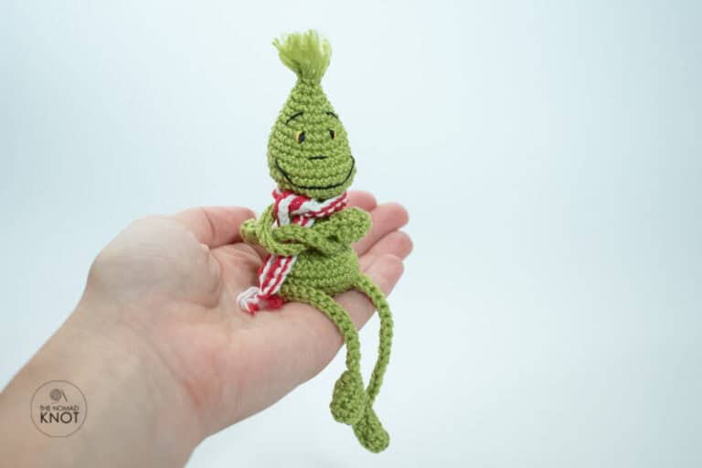 crochet posable skinny grinch free pattern on top of a hand