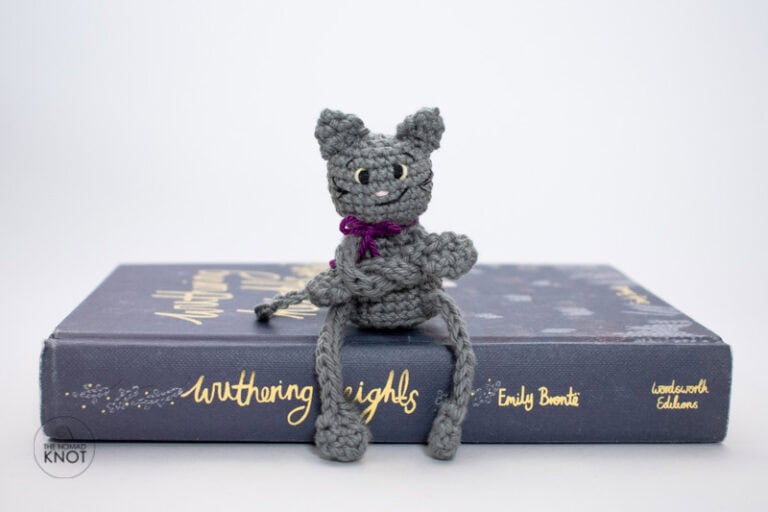 crochet posable black cat amigurumi sitting on a book. free halloween pattern