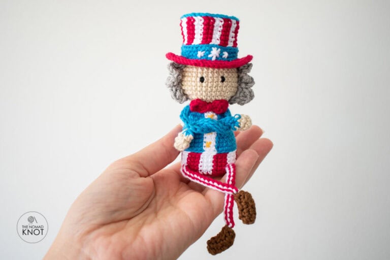 Amigurumi Uncle Sam free pattern held by one hand on a white empty background
