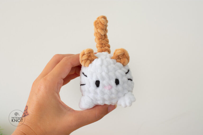 a no-sew crochet cat plush free pattern white and orange held by a hand