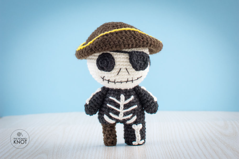 Crochet Pirate Jack Skeleton free pattern on top of a white shelf and blue background