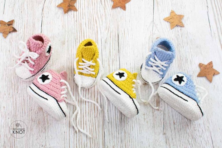 Beautiful crochet baby shoes free pattern on top of a wooden table featuring 3 sets of shoes colors yellow, blue and pink